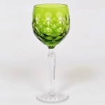 CRISTAL OVERLAY, uma (1) taça de pé alto para vinho, translúcida, bojo verde musgo sobre incolor, lapidado em estrelas e esferas, fuste com facetado hexagonal e base em bolacha com fundo estrelado, ambos incolores, medindo 19 cm altura, vide foto.