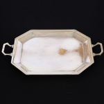 METAL PRATEADO, uma (1) bandeja octogonal lisa com borda e alças reforçadas, sem marca de manufatura aparente, medindo 60 x 41 cm até as alças, sinais de uso, vide foto.