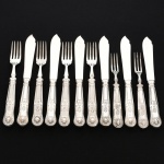 FAQUEIRO, doze (12) talheres para peixe, cabo relevado em frisos, conchas e volutas, sendo: 6 espátulas e 6 garfos, confeccionados em metal prateado, medindo a maior peça 20,5 cm comprimento, vide foto.