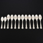 FAQUEIRO, doze (12) colheres, cabo relevado em frisos, conchas e volutas, sendo: 10 para chá e 2 para café, confeccionadas em metal prateado, medindo a maior peça 13,5 cm comprimento, vide foto.