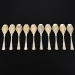FAQUEIRO, dez (10) colheres para sobremesa, cabo relevado em frisos, conchas e volutas, concavidade com vermeil e relevada em frutas, confeccionadas em metal prateado, vide foto.