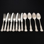 FAQUEIRO, doze (12) talheres de serviço, cabo relevado em frisos, conchas e volutas, sendo: 4 facas, 4 colheres e 4 garfos, confeccionados em metal prateado, medindo a maior peça 24 cm comprimento, marcado na lâmina da faca EWART PERKINS & COMPANY Ltd., vide foto.