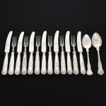 FAQUEIRO, quinze (15) talheres para sobremesa, cabo relevado em frisos, conchas e volutas, sendo: 7 facas, 2 colheres e 6 garfos, confeccionados em metal prateado, medindo a maior peça 18,5 cm comprimento, marcado na lâmina da faca EWART PERKINS & COMPANY Ltd., vide foto.