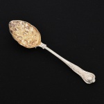 FAQUEIRO, uma (1) berry spoon, cabo relevado em frisos, conchas e volutas, concavidade com vermeil e relevada em frutas, confeccionada em metal prateado, medindo 22 cm comprimento, vide foto.