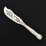 FAQUEIRO, uma (1) espátula para peixe, cabo relevado em frisos, conchas e volutas, confeccionada em metal prateado, medindo 31 cm comprimento, vide foto.