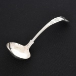FAQUEIRO, uma (1) concha para molho, cabo relevado em frisos, conchas e volutas, confeccionada em metal prateado, medindo 18 cm comprimento, vide foto.
