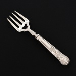 FAQUEIRO, um (1) garfo para assado, cabo relevado em frisos, conchas e volutas, confeccionada em metal prateado, medindo 23 cm comprimento, vide foto.