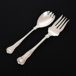 FAQUEIRO, conjunto para servir salada com dois (2) itens, cabo relevado em frisos, conchas e volutas, confeccionados em metal prateado, sendo: 1 garfo e 1 colher, medindo 23,5 cm comprimento, vide foto.