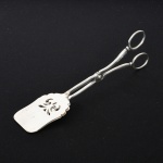 METAL PRATEADO, uma (1) espátula, tipo tesoura para servir frios, marca CP & Co., medindo 21,5 cm comprimento, vide foto.