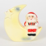 FAIANÇA, um (1) cofre, modelado na forma de Papai Noel sentado na lua, policromado, marca WEISS (São José dos Campos, SP, 1941 a 1995, empresa que nasceu da capacidade criativa de Inês Weiss, que desenvolveu uma pintura colorida e exuberante, inicialmente pintava peças da Fábrica Santo Eugênio, com a saída do seu marido Roberto Weiss e do seu cunhado Mário Weiss da Fábrica Santo Eugênio para fundar a Irmãos Weiss, Inês passou a decorar as peças artesanalmente entre os anos 40/60, da própria fabrica do marido e do cunhado, entre as décadas de 60/90 a produção foi industrializada), medindo 11 cm altura, vide foto.