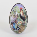 DIVERSOS, uma (1) caixa vazia no formato ovoide, ornamentação policromada representando galo, coelho e flores, confeccionada em folha de flandres, medindo 11 cm, acompanham 8 fitas do Senhor do Bonfim, vide foto.