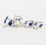 PORCELANA HOLANDESA, três (3) itens, pintados a mão na técnica blue and white, região de Delft: 1 escultura representando vaca, medindo 8 cm comprimento; 2 (par) tamancos, medindo 5,5 cm comprimento, vide foto.