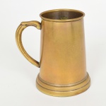 BRONZE, uma (1) antiga caneca, formato ligeiramente cônico, lisa, alça curvilínea com frisos arrematada por volutas, base em degraus, marca REBOUÇAS, medindo 14 cm altura, sinais de uso, demanda novo banho em prata, vide foto.