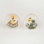 PORCELANA JAPONESA, dois (2) pequenos pratinhos para petiscos, ornamentações distintas em policromia com pássaros e elementos vegetalistas, arremates com frisos a ouro, marca representada pela letra H dentro de losango, além de caracteres e legenda de origem, medindo 9 cm diâmetro, vide foto.