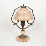 LUMINÁRIA, uma (1) base para abat-jour para um lume, confeccionada em alabastro torneado, monture em bronze relevado em elementos vegetalistas e volutas, selo da CARLO MONTALTO (Industria e Comércio, Rua Galvão Bueno 544  562, São Paulo), medindo 33 cm altura, falta a parte elétrica, sinais de uso, vide foto.