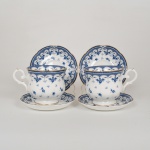 PORCELANA TAILANDESA, par (2) xícaras de chá, modeladas em gomos, ornamentação vegetalista e barrado geométrico na tonalidade azul sobre fundo branco, arremates a ouro, marca ROYAL BONE CHINE, modelo BLUE LEAF, Thailand, acompanham dois pires sobressalentes, ideais para coleção de cristaleira, vide foto.
