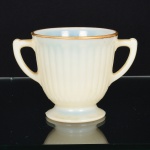 OPALINA FRANCESA, uma (1) antiga e pequena taça com alças, moldada em caneluras verticais, borda com arremates a ouro, medindo 8,5 cm altura, vide foto.