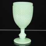 VIDRO OPALINADO, uma (1) taça de pé alto com fuste no formato de balaustre, modelagem no padrão dito bico de jaca, tonalidade verde leitosa, dita milk glass, medindo 15 cm altura, vide foto.