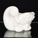 FAIANÇA, uma (1) floreira, modelada na forma de pato com filhotes, tonalidade branca, marca WEISS (São José dos Campos, SP, 1941 a 1995, empresa que nasceu da capacidade criativa de Inês Weiss, que desenvolveu uma pintura colorida e exuberante, inicialmente pintava peças da Fábrica Santo Eugênio, com a saída do seu marido Roberto Weiss e do seu cunhado Mário Weiss da Fábrica Santo Eugênio para fundar a Irmãos Weiss, Inês passou a decorar as peças artesanalmente entre os anos 40/60, da própria fabrica do marido e do cunhado, entre as décadas de 60/90 a produção foi industrializada), medindo 17 cm comprimento, vide foto.