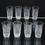 VIDRO, oito (8) taças para licor, incolores e translúcidas, formato ligeiramente obcônico, lapidadas em sulcos com barrado geométrico, base facetada, medindo 6 cm altura, vide foto.