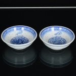) PORCELANA CHINESA, par (2) pequenos bowls, ornamentação na tonalidade azul sobre fundo branco, representando dragão celestial, morcegos e geométricos, padrão dito grão de arroz (denominação dada as peças em porcelana que, após minuciosamente entalhadas com estilete, são embebidas diversas vezes em barbotina, antes da queima, para dar este efeito), marca possessória representada pelas letras e datação AD 4-6-88, fundo com marca de origem em legenda e caracteres, medindo 6,5 cm diâmetro e 2,5 cm altura, vide foto.
