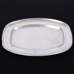 AÇO INOX, uma (1) travessa quase oval com extremidades chanfradas, marca EBERLE (Abramo Eberle 1880, Monte Magrè 1945, Caxias do Sul, veio com uma das primeiras levas de imigrantes italianos para o Brasil em 1884 junto com seus pais Giuzeppe Eberle e Luigia Zanrosso, seu pai abriu uma pequena funilaria mas como tinha que trabalhar na lavoura quem cuidava era a mãe e o pequeno Abramo ajudava na funilaria; em 1896 quando o pai resolveu vender a funilaria para concentrar os esforços da família na lavoura Abramo, com 16 anos de idade, se propôs a comprá-la do pai, em 1918 já com o nome Abramo Eberle & Cia iniciou a fabricação de talheres e utensílios de mesa, morreu em 1945 com 65 anos de idade e os filhos deram continuidade aos negócios até 1984 quando venderam para o Grupo Zivi), apresenta riscos e sinais de uso, medindo 35 x 24 cm, vide foto.