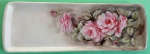 Bandeja retangular em porcelana pintada a mão com rosas e folhas medindo 38x13 cm.