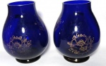 Par de vasos em vidro bojudos na cor azul royal com flores e filetes dourados medindo 16x7 cm.