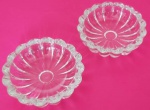 Par de mategueiras em vidro transparente redondo com bordas onduladas medindo 7x2 cm.