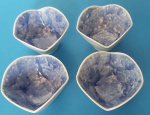 Quatro mini bowls em porcelana branca com centro azul mesclado ondulado com frisos azuis medindo 9x8,5 cm..