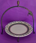 Suporte aramado com nuances dourados com prato decorado em porcelana Oxford na cor bege com barrado med 33x32 e prato 26 cm.  Aramado no guarda roupa arlete
