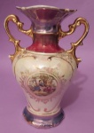 Antiga anfora década de 50/60 em porcelana furtacor apresenta cenas galantes pintado à mão com acabamento dourados e filetes de arabescos medindo 19x14 cm..