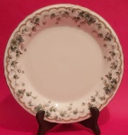 Prato decorativo em porcelana Narumi com parreiras e uvas com bordas e frisos dourados medindo 26 cm..