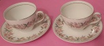 Par de xícaras para chá em porcelana Inglesa na cor creme com motivos florais e filetes prateados medindo 8x9cm..