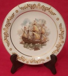 Prato decorativo de porcelana Schmidt com cenas nautica (caravelas ) bordas com arabescos dourados acompanha suporte medindo 19 cm..
