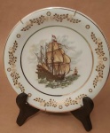 Prato decorativo de porcelana Schmidt com cenas nautica (caravelas ) bordas com arabescos dourados acompanha suporte medindo 19 cm..