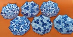 Conjunto de seis pratos de sobremesa octógono em cerâmica nas cores creme com flores e folhas azuis medindo 16 cm.