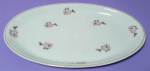 Travessa oval  em porcelana branca Real com flores e folhas na cor rosa com filetes dourados medindo 28x17 cm.