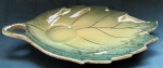 Folha verde decorativa de parede em cerâmica vitrificada com filetes dourados medindo 28x19x2 cm.