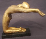 Escultura de homem em metal dourado com base em madeira laqueada preta medindo 19x14x6cm.