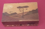 Caixa de machetária caracterizada por encrustação de madeira representando paisagens medindo 5,5x16x10 cm.