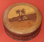 Antiga caixa de machetária caracterizada por encrustação de madeira redonda representando paisagenscoqueiro medindo 17x6cm.