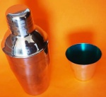 Kit para bar, coqueteleira em inóx e copinho em prata com parte interna verde no estado medindo 18 e 6x7 cm.
