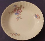 Tigela redonda em porcelana branca Porto Ferreira com bordas onfuladas e frisos canelados dourados com detalhes florais medindo 22x5 cm.