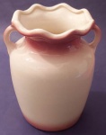 Vaso em cerâmica vintage apresenta acabamento por tons com bordas onduladas e alças laterais cor rosa em degradee medindo 16x19 cm.
