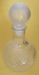 Garrafa redonda com tampa em vidro transparente Bico de Jaca medindo 26x7 cm.