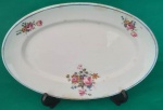 Travessa em porcelana Nadir antiga com filetes azuis na borda e flores com marcas do tempo medindo 24x16 cm.