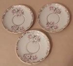 Trio de pratinhos  decorativos de parede em porcelana Schmidt com flores, folhas e arabescos e filetes dourados medindo 14,cm