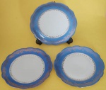 Trio de pratos decorativos em porcelana Renner Porto Alegre na cor branca com azul e filetes e arabescos dourados medindo 17 cm.