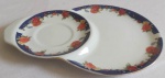Porta xícara estendida em porcelana Santini Italia com borda dourada e flores e folhas com detalhes azul medindo 23x15 cm